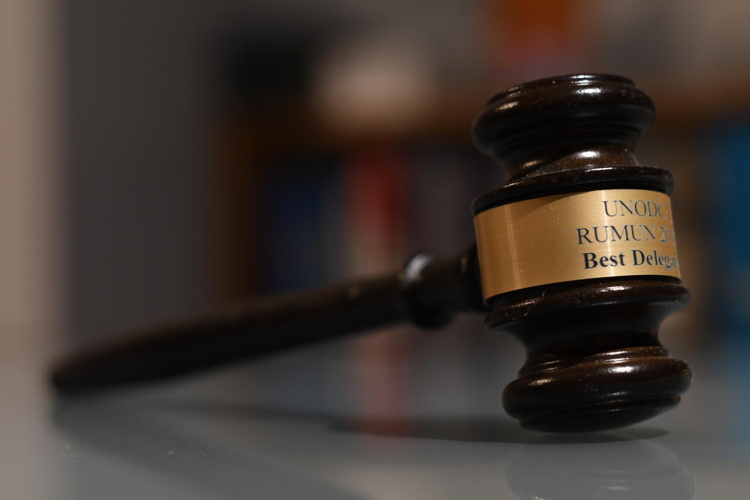 Feature image for the article: A gavel resting next to a group of international flags